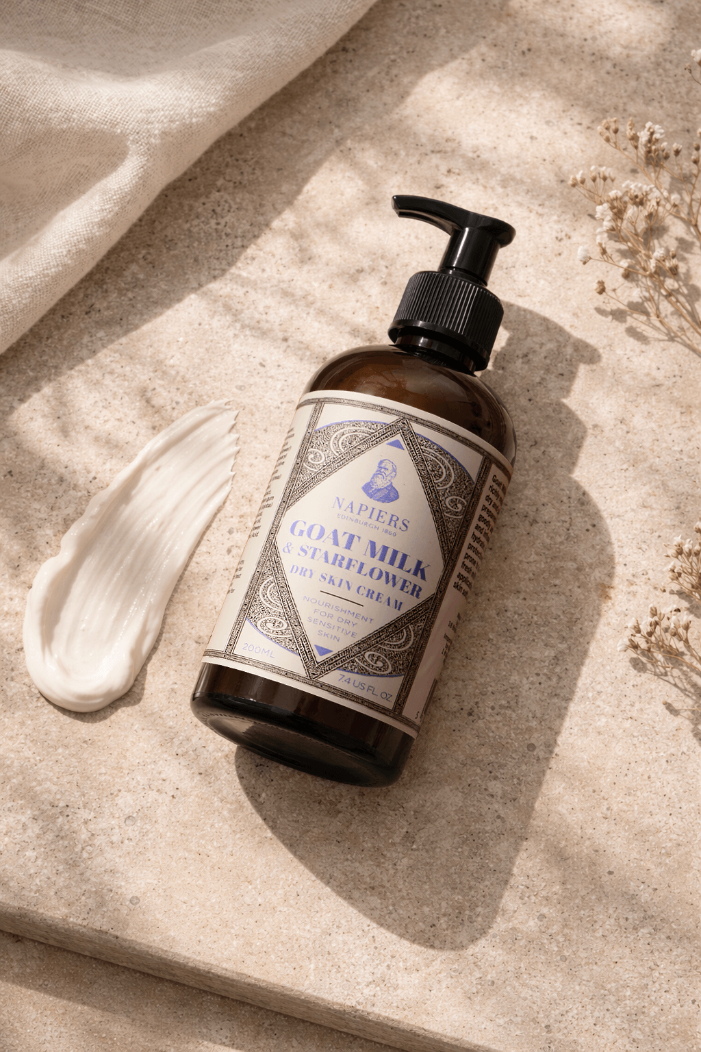 Napiers Goat Milk & Starflower Cream bottle displayed with creamy texture swatch on natural stone background