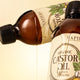 Two Napiers Organic Castor Oil bottles with oil streaming from tilted bottle